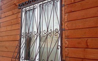 решетка кованая дутой формы для окна деревянного дома